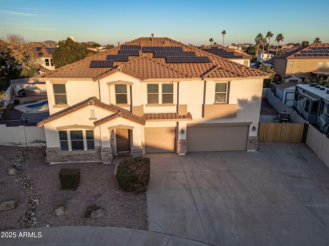 mediterranean / spanish home featuring solar panels and a garage