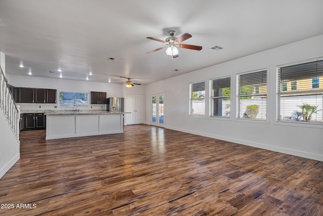 unfurnished living room with ceiling fan and dark hardwood / wood-style flooring