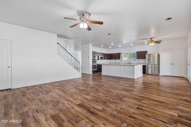 unfurnished living room with ceiling fan and dark hardwood / wood-style flooring