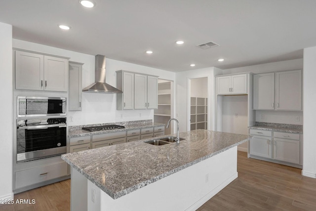 14789 W Lariat Ln, Surprise, AZ 85387 - kitchen with stainless steel appliances, wall chimney exhaust hood, a sink, light wood-type flooring, and recessed lighting