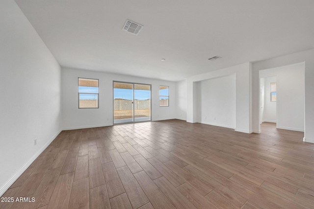 14789 W Lariat Ln, Surprise, AZ 85387 - empty room featuring wood finished floors, healthy amount of natural light, and baseboards