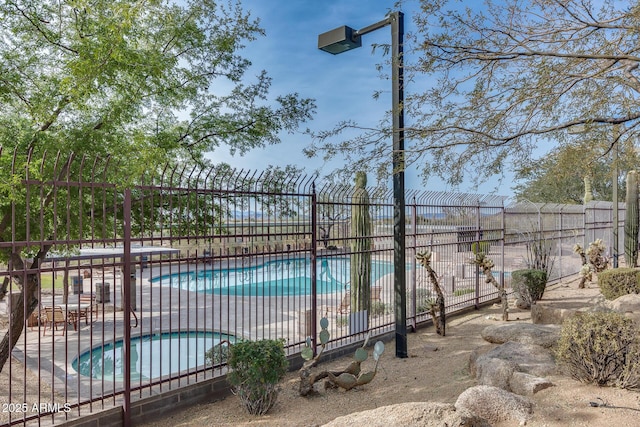 view of swimming pool featuring an in ground hot tub