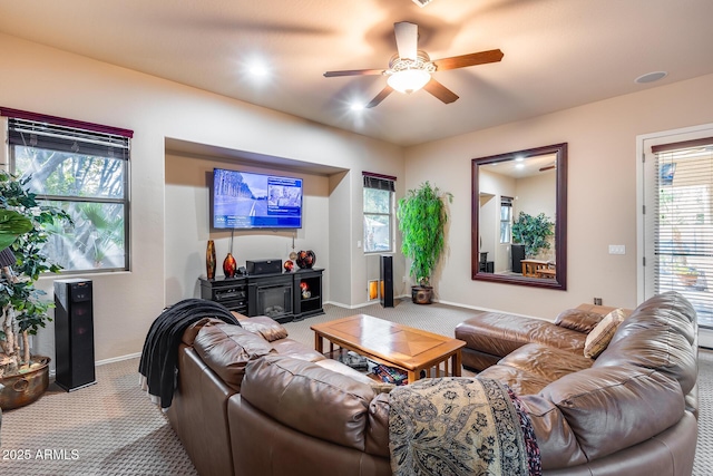 carpeted living room with ceiling fan