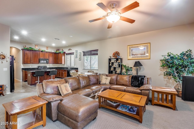 living room with ceiling fan and light colored carpet