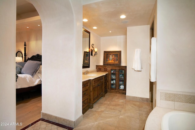 bathroom featuring a bathing tub, vanity, and wood-type flooring