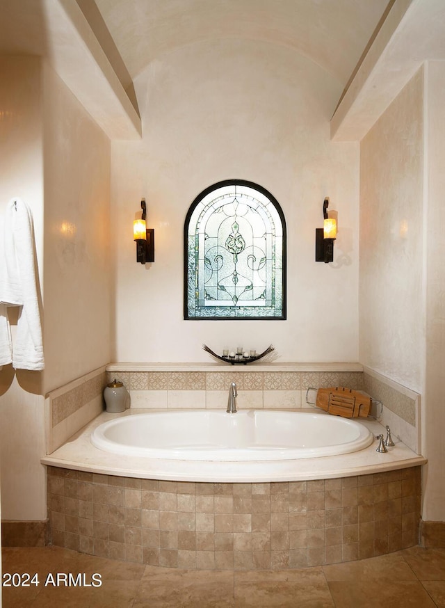 bathroom featuring tile patterned floors, tiled bath, and vaulted ceiling