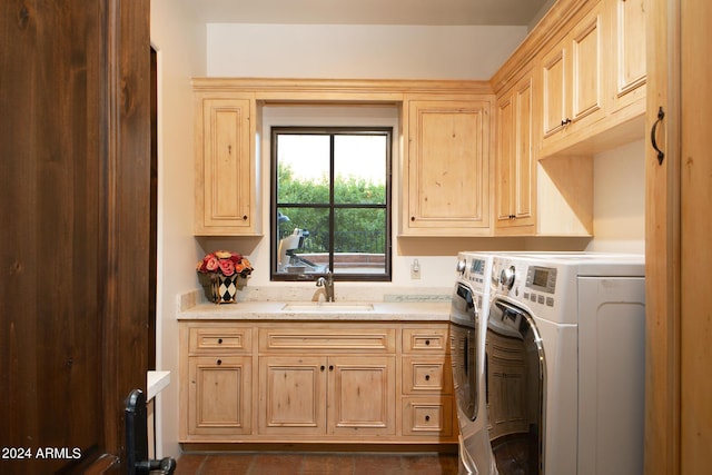 laundry room featuring cabinets, independent washer and dryer, and sink