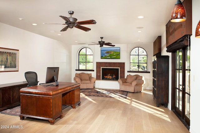 office area with ceiling fan, plenty of natural light, and light wood-type flooring