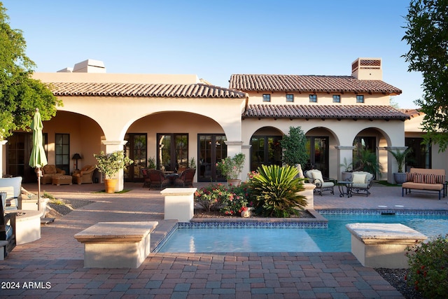 back of property with a patio area and an outdoor hangout area