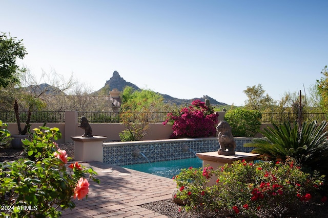 view of pool with a mountain view, pool water feature, and a patio