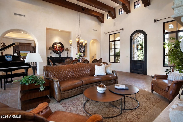 living room featuring beamed ceiling, a towering ceiling, and a chandelier