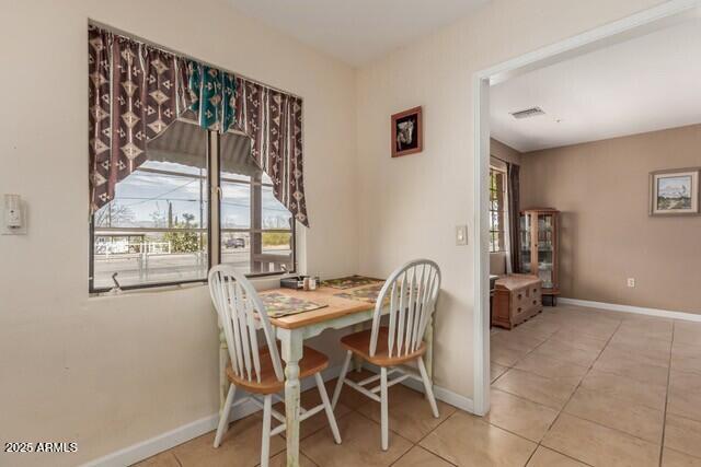 tiled dining space featuring visible vents and baseboards