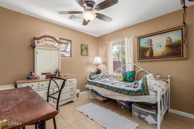 bedroom featuring light tile patterned floors, visible vents, ceiling fan, and baseboards