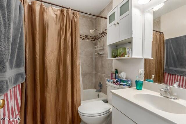 full bath with toilet, shower / bathtub combination with curtain, and vanity
