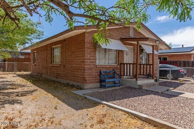 exterior space featuring brick siding and fence