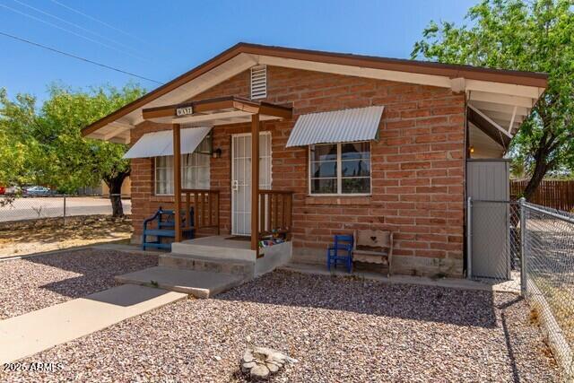 view of front of house featuring brick siding and fence