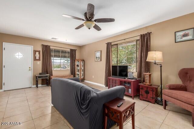 living room featuring a healthy amount of sunlight, light tile patterned flooring, and ceiling fan