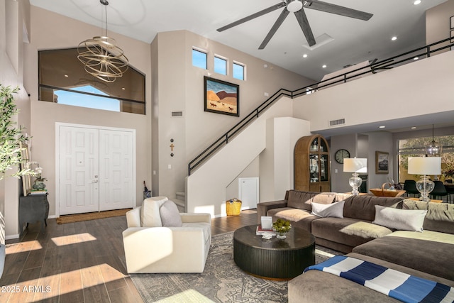 living room featuring dark wood-type flooring, a healthy amount of sunlight, and a high ceiling