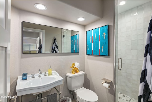 bathroom with sink, toilet, and a shower with door