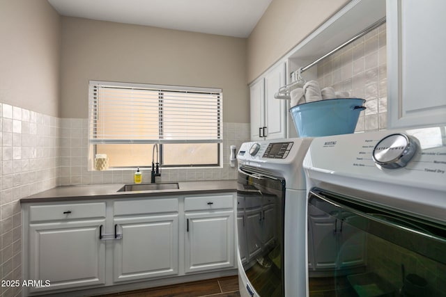 laundry room featuring cabinets, washing machine and dryer, sink, and tile walls