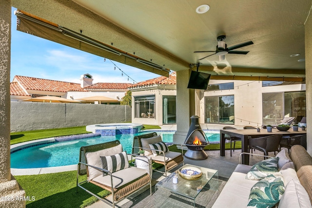 exterior space featuring an outdoor living space, ceiling fan, and an in ground hot tub