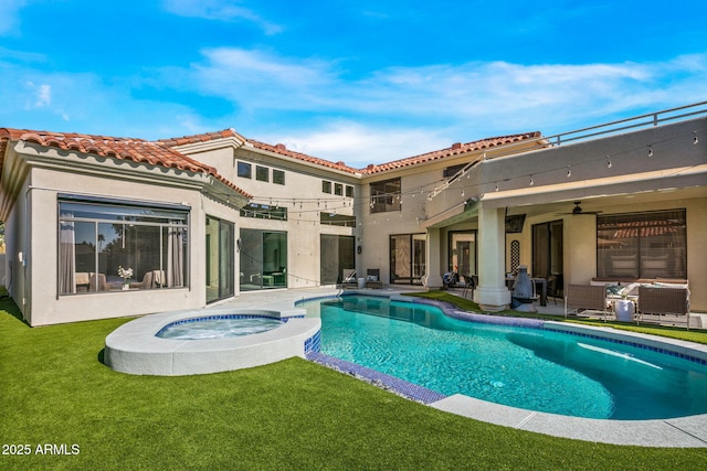 back of house with a pool with hot tub, a lawn, ceiling fan, and a patio area