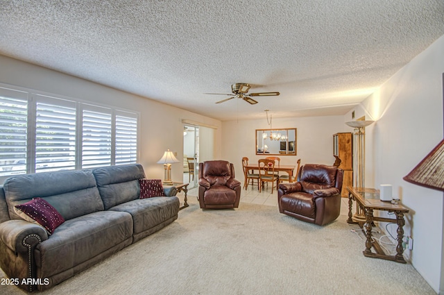 living room featuring carpet flooring, a textured ceiling, and ceiling fan with notable chandelier