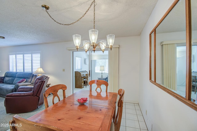 dining area with a textured ceiling, a chandelier, and light tile patterned floors