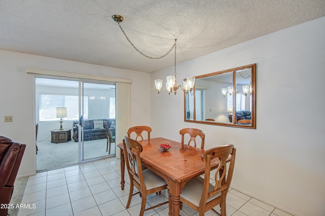 dining space featuring an inviting chandelier, light tile patterned floors, and a textured ceiling