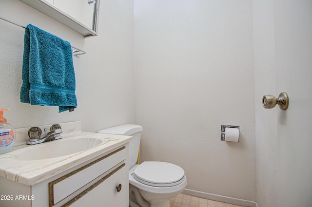half bath featuring baseboards, toilet, and vanity