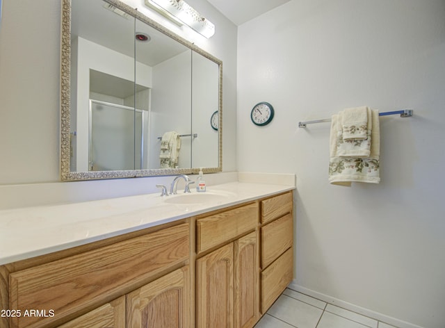 full bath with tile patterned flooring, vanity, baseboards, and an enclosed shower