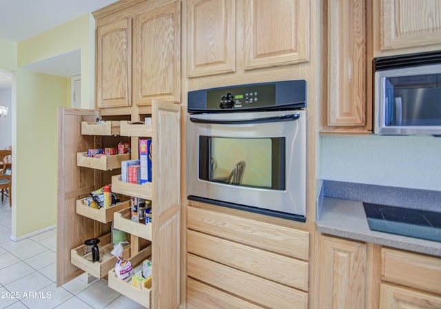 kitchen featuring light brown cabinets, stainless steel appliances, and light tile patterned floors