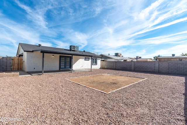 back of property with central AC and a patio area