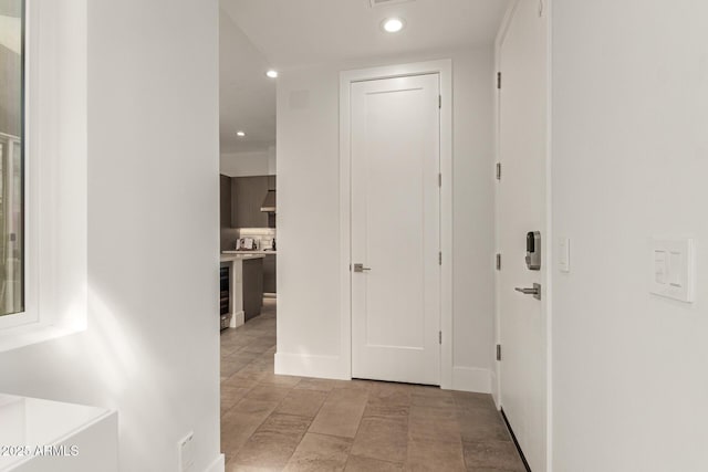 hallway with beverage cooler and recessed lighting