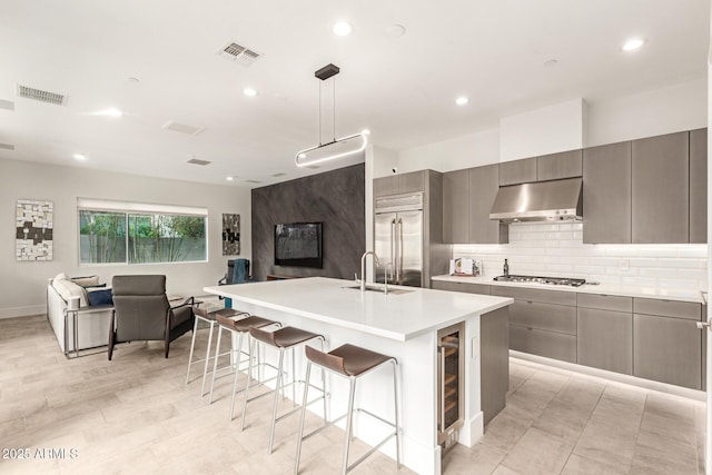 kitchen featuring open floor plan, visible vents, under cabinet range hood, and stainless steel appliances