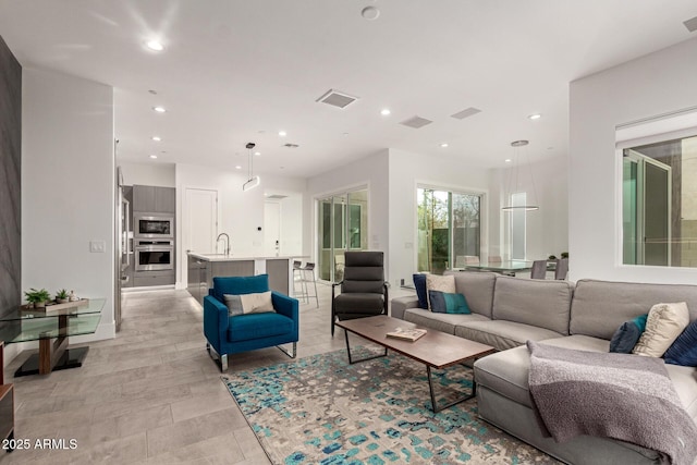 living area featuring visible vents and recessed lighting