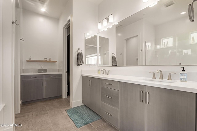 full bathroom featuring a sink, visible vents, a shower, and double vanity