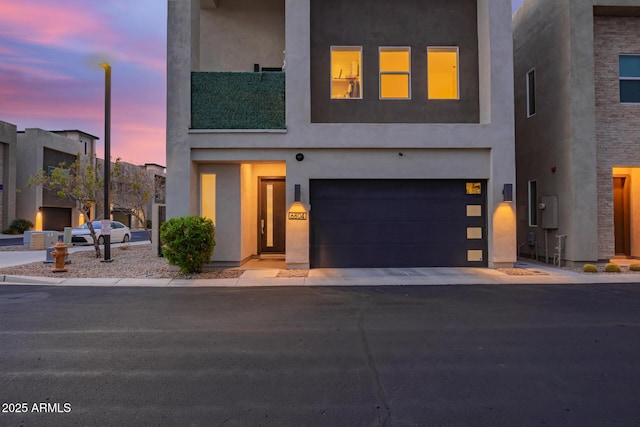 view of front of property featuring a garage, driveway, and stucco siding