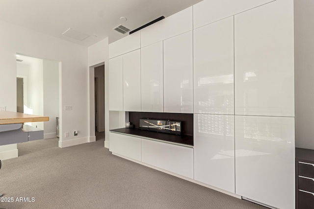 unfurnished living room featuring visible vents, baseboards, and carpet flooring