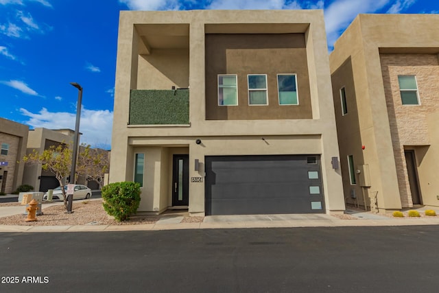 view of front facade with a garage, driveway, and stucco siding