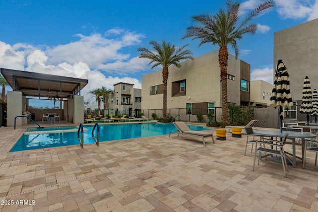 pool with a patio and fence