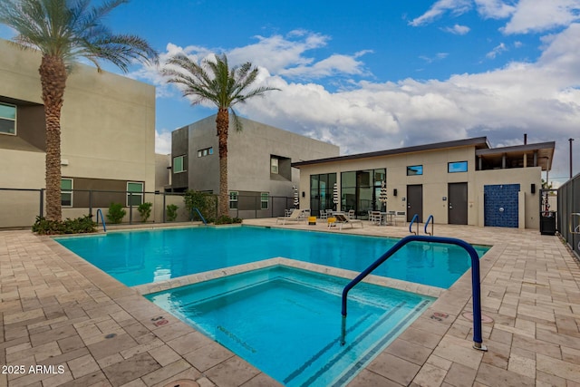 pool with a patio area and fence