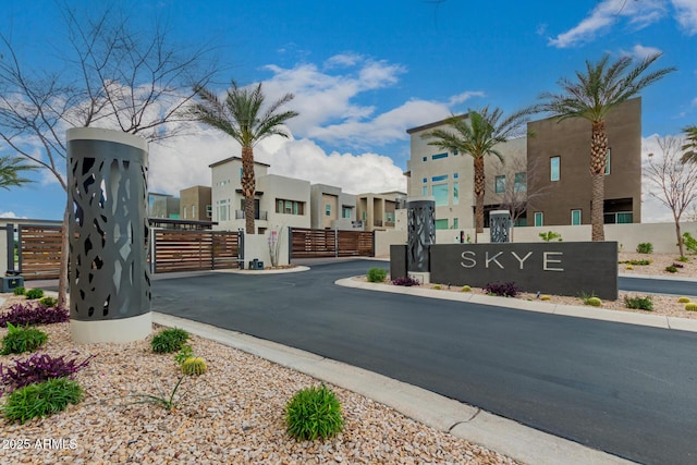 view of road with curbs, a residential view, a gated entry, and a gate