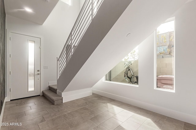 foyer with stairway and baseboards