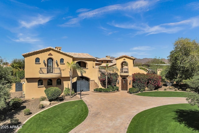 10894 E Turquoise Ave, Scottsdale, AZ 85259 - mediterranean / spanish-style house with a balcony, a gate, stucco siding, curved driveway, and a tiled roof