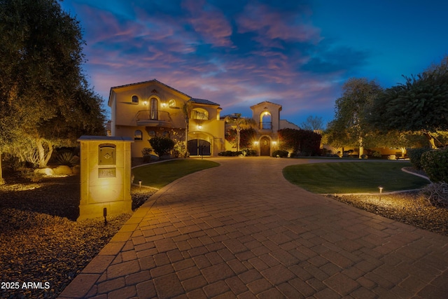 10894 E Turquoise Ave, Scottsdale, AZ 85259 - mediterranean / spanish-style house with a front lawn, a balcony, stucco siding, and curved driveway