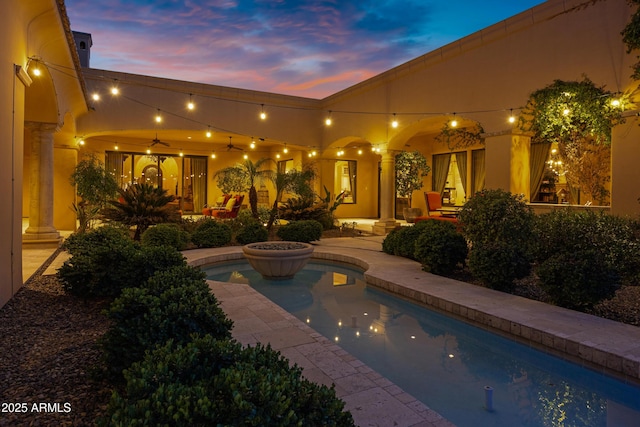 10894 E Turquoise Ave, Scottsdale, AZ 85259 - pool at dusk with a patio area, an outdoor pool, and a ceiling fan