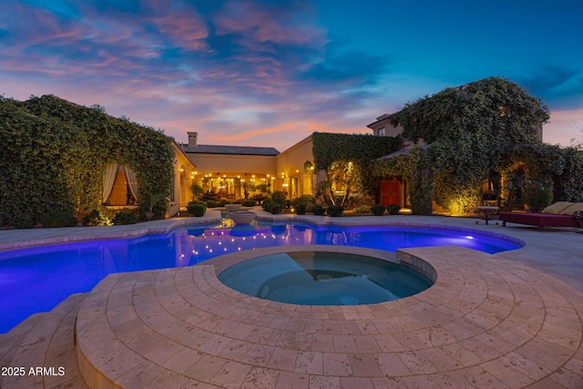 10894 E Turquoise Ave, Scottsdale, AZ 85259 - pool at dusk with a pool with connected hot tub and a patio area