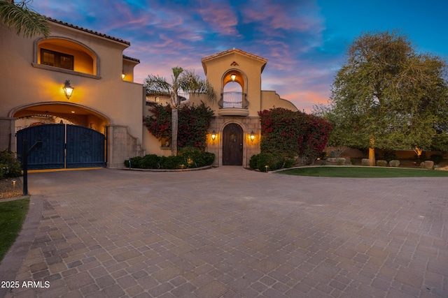 10894 E Turquoise Ave, Scottsdale, AZ 85259 - mediterranean / spanish-style house featuring decorative driveway, a gate, and stucco siding