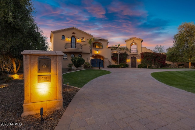 10894 E Turquoise Ave, Scottsdale, AZ 85259 - mediterranean / spanish-style home with a yard, curved driveway, a balcony, and stucco siding
